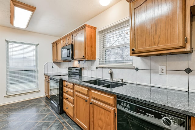 kitchen with sink, decorative backsplash, dark stone counters, and black appliances