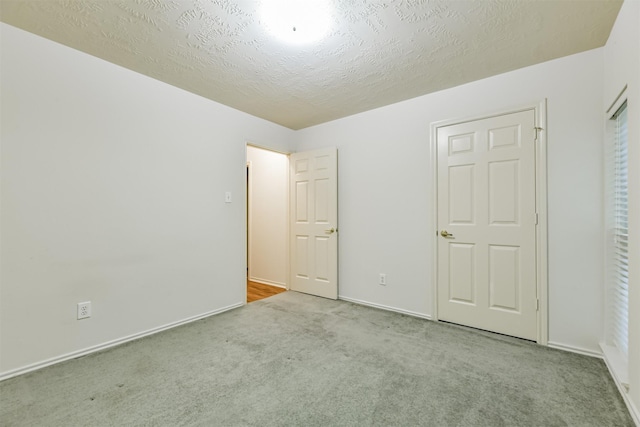 unfurnished bedroom featuring light colored carpet and a textured ceiling