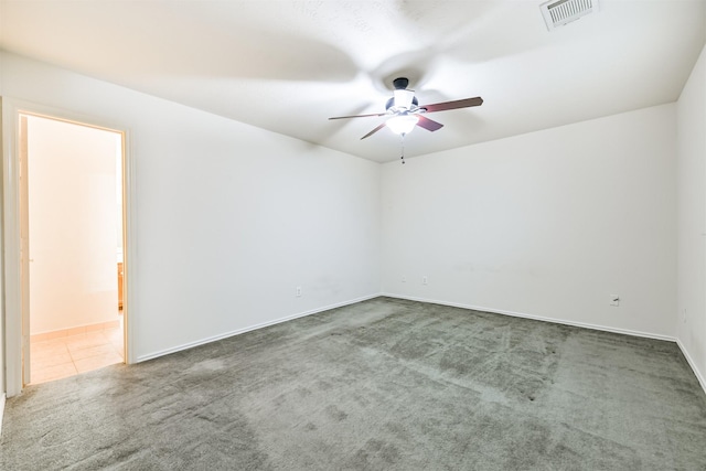 spare room with ceiling fan and dark carpet