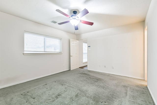 carpeted spare room featuring ceiling fan