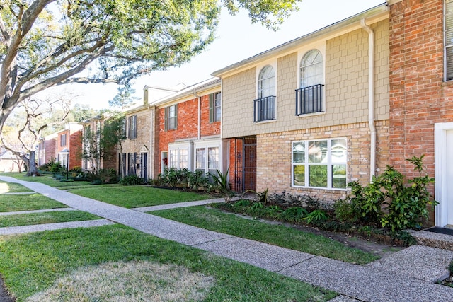 view of property with a front yard and brick siding