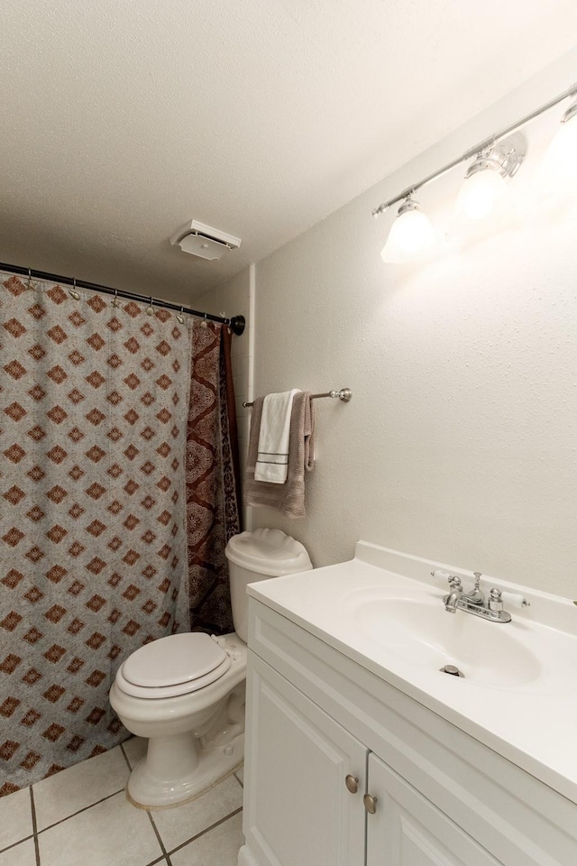 bathroom featuring vanity, tile patterned floors, a textured ceiling, and toilet