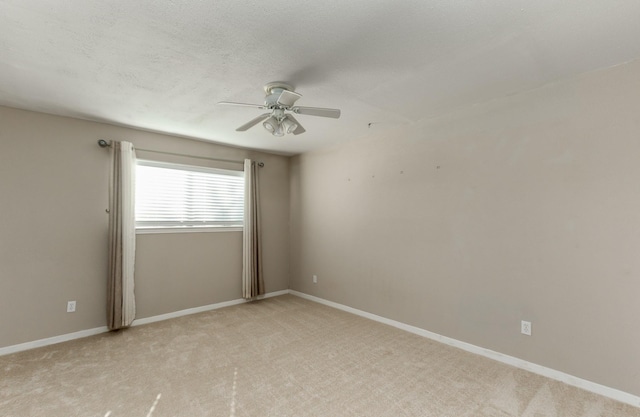 unfurnished room featuring ceiling fan, baseboards, a textured ceiling, and light colored carpet