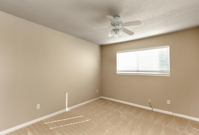 empty room featuring ceiling fan and light colored carpet