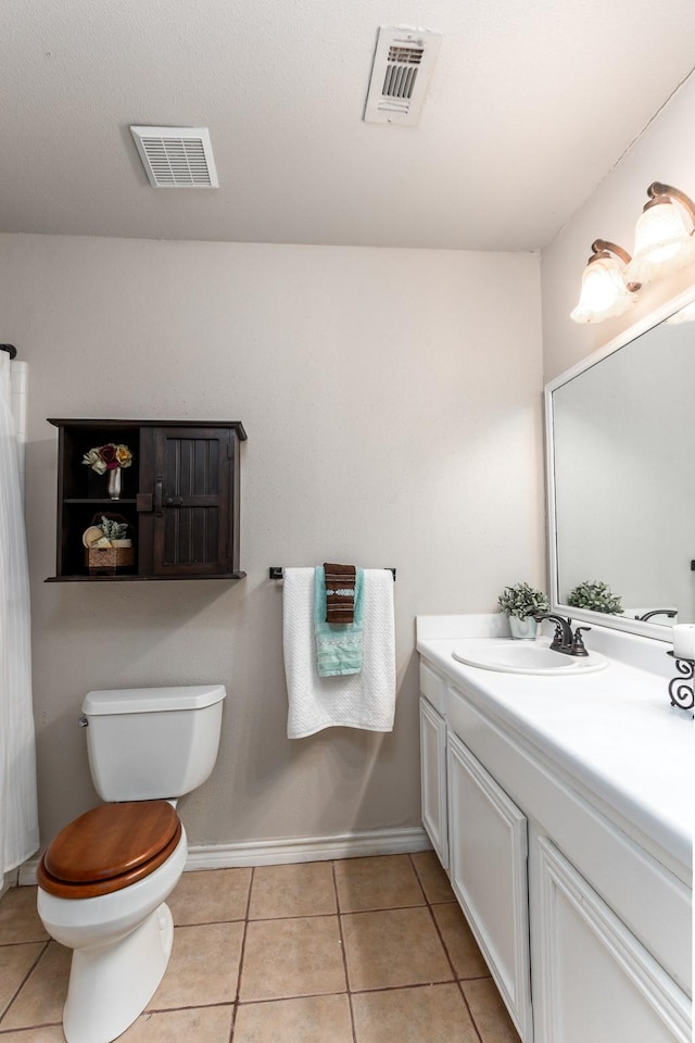 bathroom featuring vanity, toilet, and tile patterned flooring