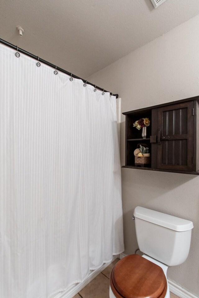 bathroom with tile patterned flooring and toilet