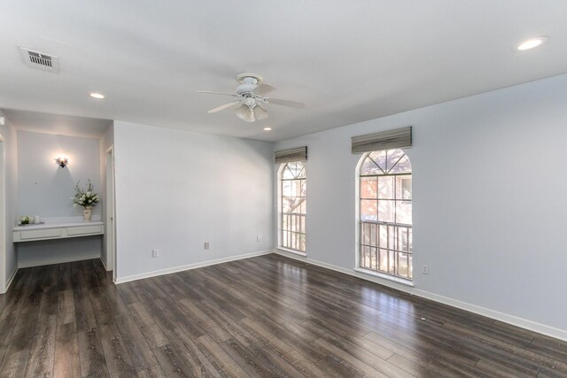 empty room with ceiling fan and dark hardwood / wood-style flooring