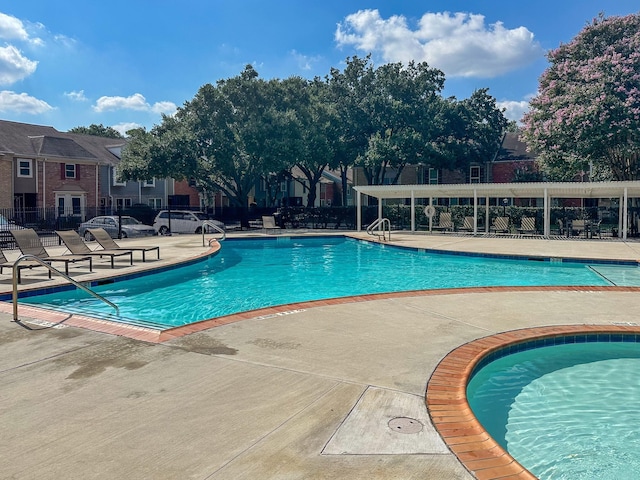 community pool featuring a patio area and fence