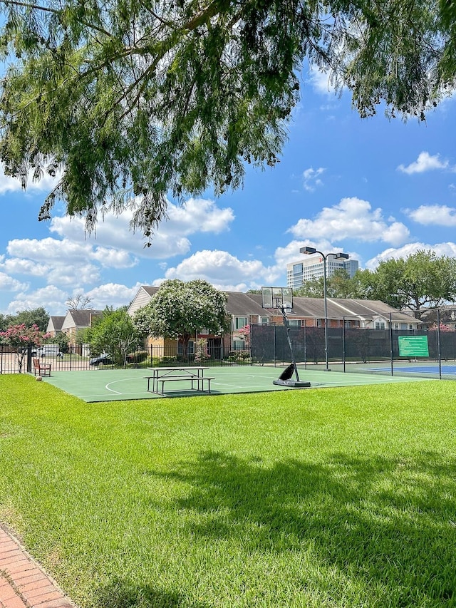 surrounding community with a yard and basketball hoop