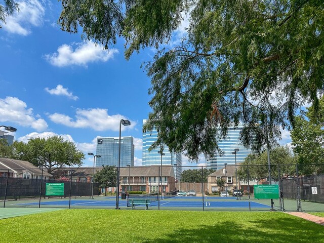 view of sport court with a lawn