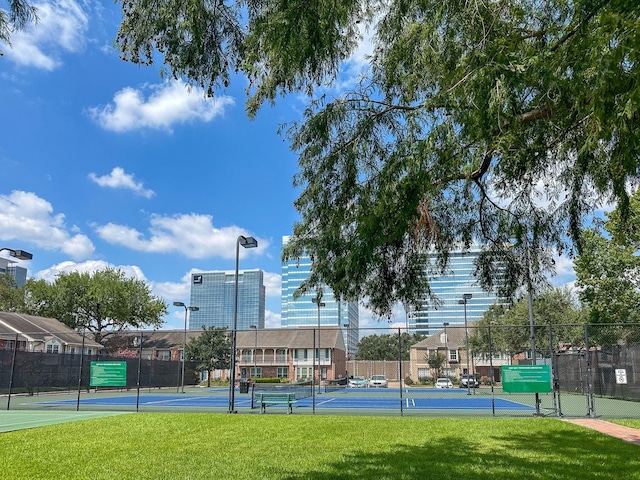 view of sport court featuring a lawn and fence