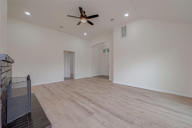 unfurnished living room featuring ceiling fan, high vaulted ceiling, a brick fireplace, and light hardwood / wood-style flooring