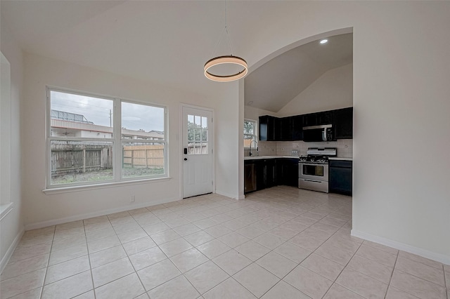 kitchen featuring lofted ceiling, sink, appliances with stainless steel finishes, tasteful backsplash, and light tile patterned flooring