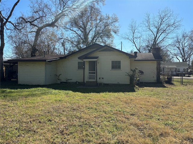 rear view of property featuring a lawn