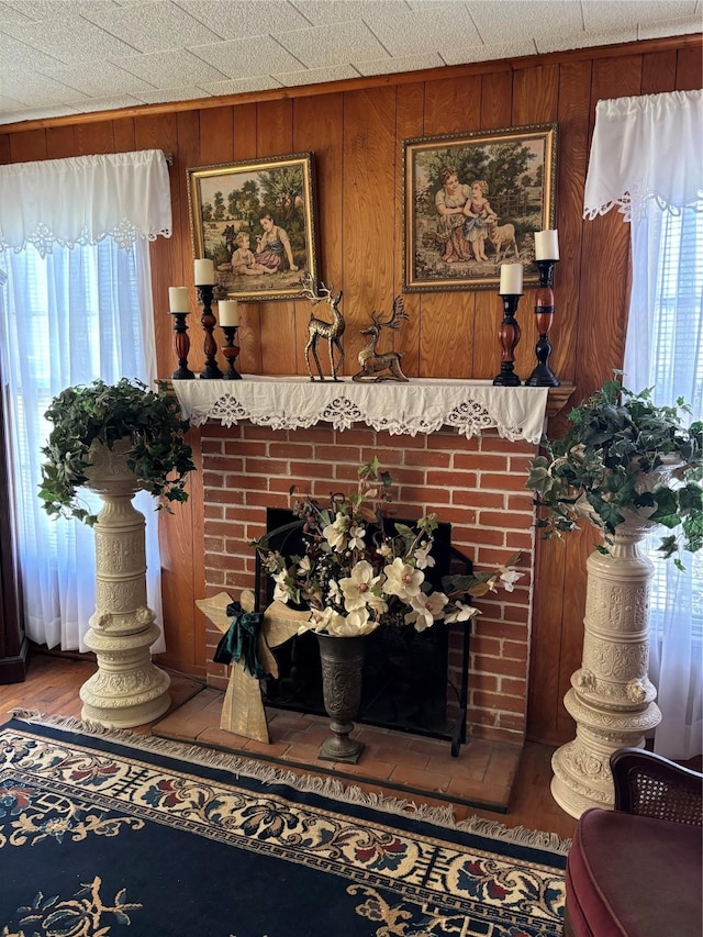 interior details featuring a fireplace, wooden walls, and wood-type flooring