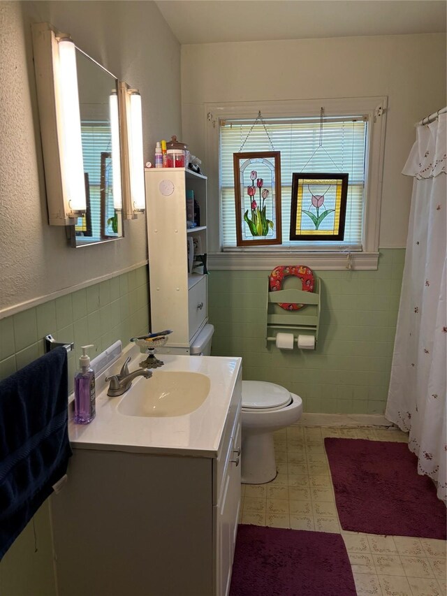 504 E Bell Ave, Crockett, TX 75835 - bathroom featuring tile walls, tile patterned floors, vanity, a wainscoted wall, and toilet