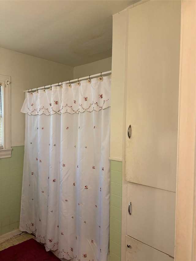 504 E Bell Ave, Crockett, TX 75835 - bathroom with tile walls, a wainscoted wall, and a shower with curtain