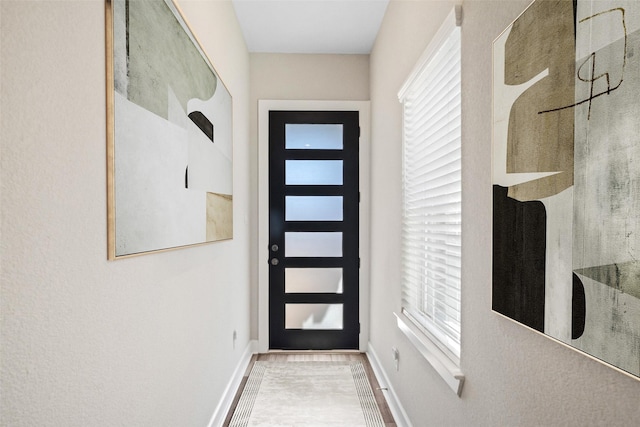 doorway to outside with baseboards