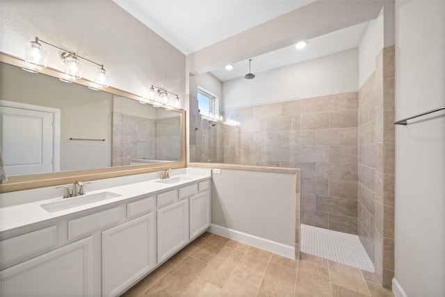 bathroom featuring double vanity, tile patterned flooring, a walk in shower, and a sink