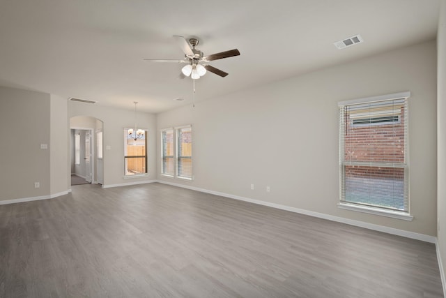 unfurnished room featuring hardwood / wood-style flooring and ceiling fan with notable chandelier