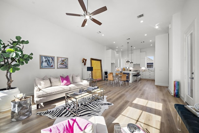 living room with ceiling fan and light hardwood / wood-style flooring