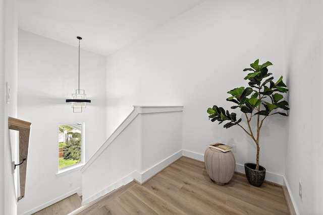 stairs with vaulted ceiling and hardwood / wood-style floors