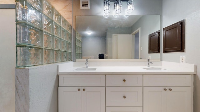 full bath featuring visible vents, a sink, and double vanity