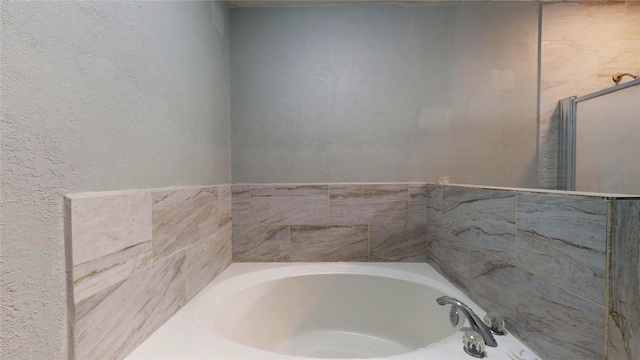 full bathroom with a bath and a textured wall