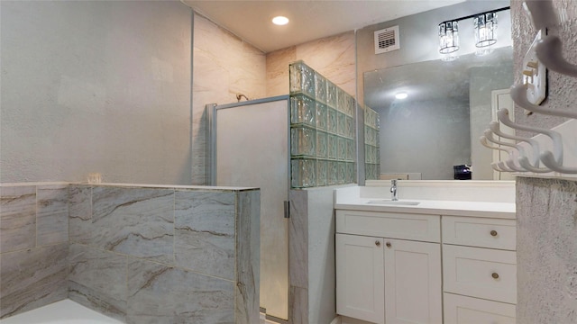 full bath with a stall shower, visible vents, and vanity