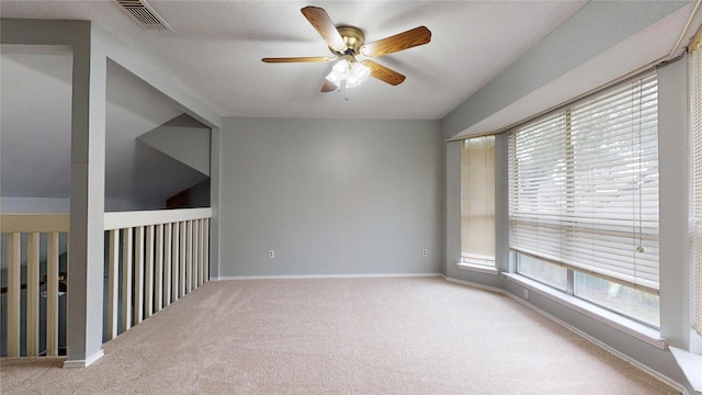 empty room featuring carpet floors, visible vents, ceiling fan, and baseboards