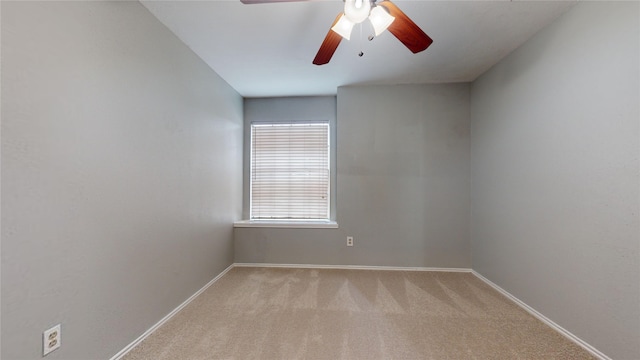 empty room featuring light carpet, ceiling fan, and baseboards