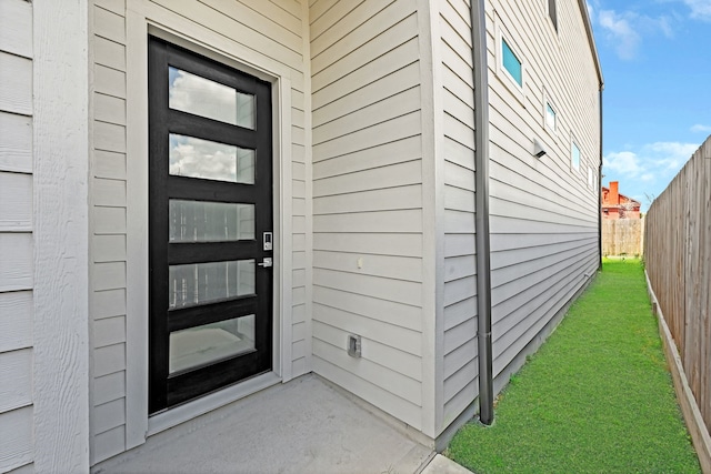 view of exterior entry with a lawn