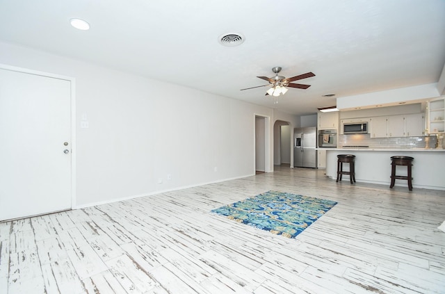 unfurnished living room with ceiling fan