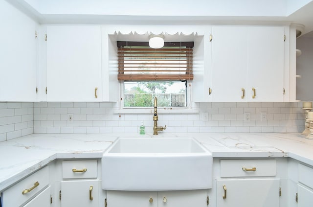 kitchen featuring tasteful backsplash, sink, and white cabinetry