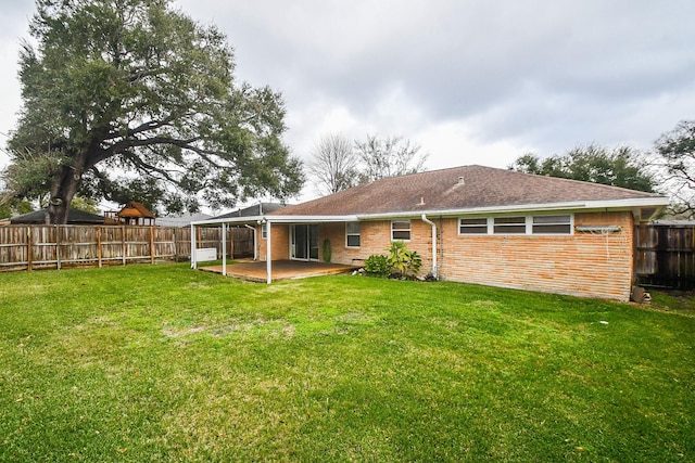 back of house featuring a patio and a yard