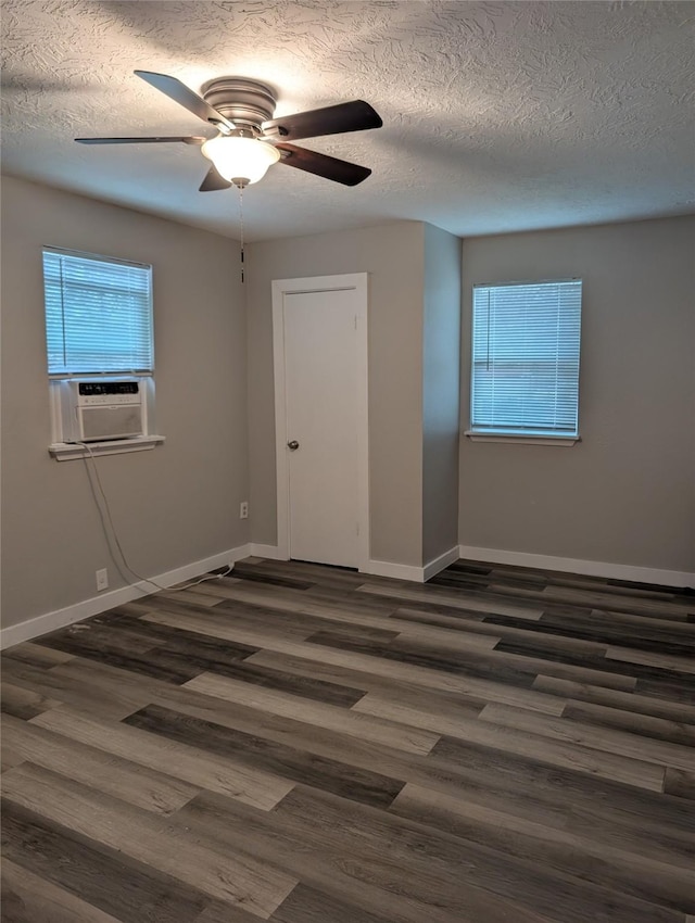 spare room featuring cooling unit, a textured ceiling, dark wood-type flooring, and ceiling fan