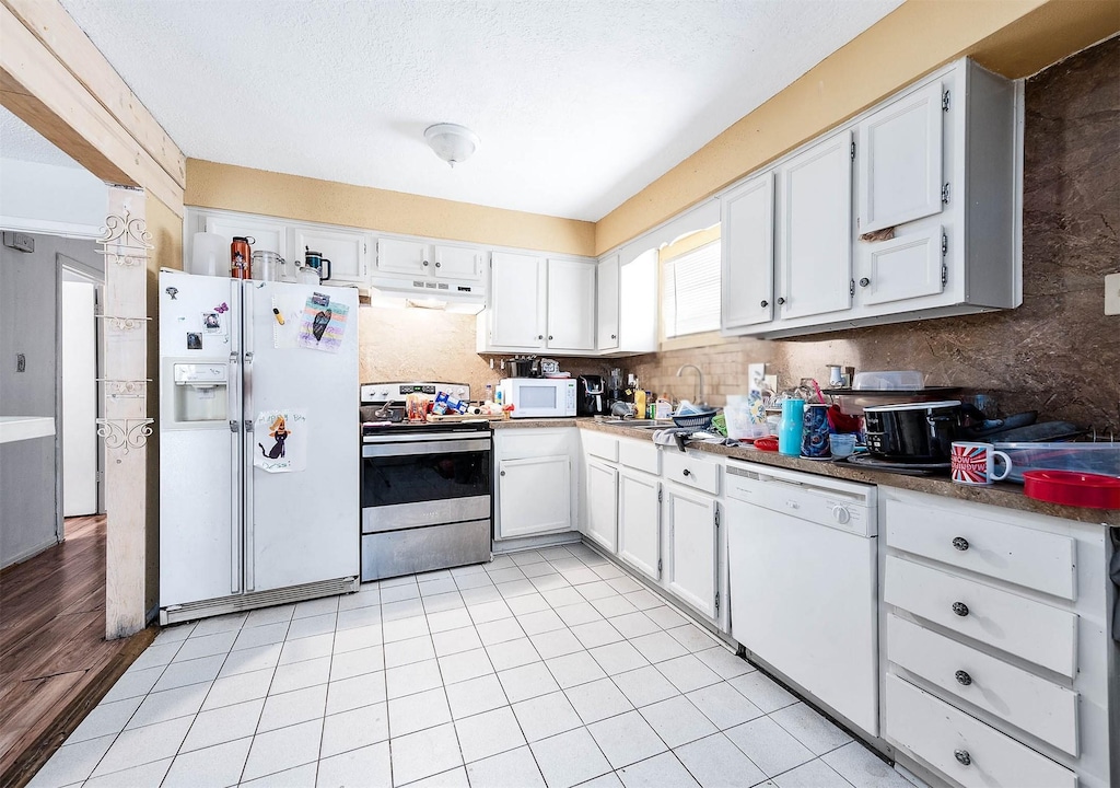 kitchen featuring white cabinetry, white appliances, sink, and light tile patterned floors