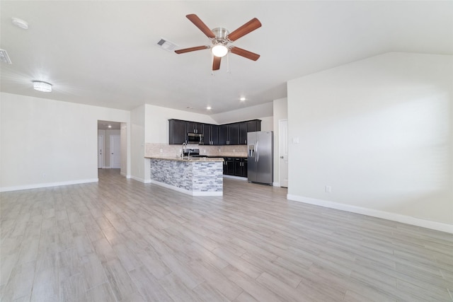 unfurnished living room featuring vaulted ceiling, ceiling fan, and light hardwood / wood-style flooring