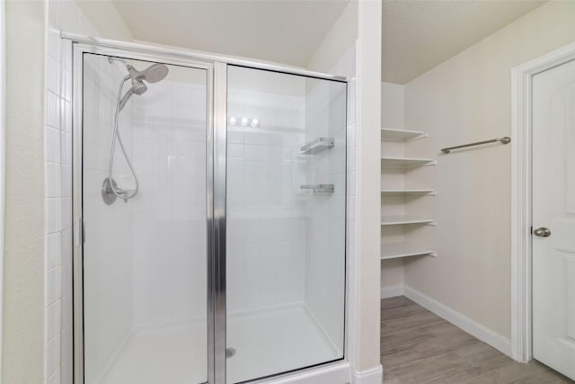 bathroom featuring wood-type flooring and an enclosed shower