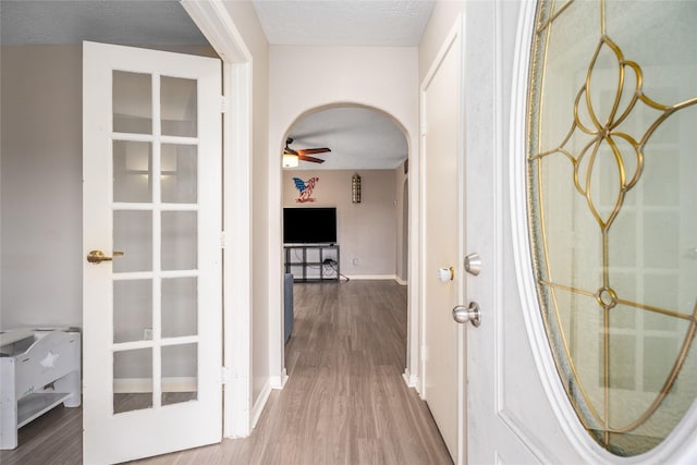 hallway with wood-type flooring and a textured ceiling