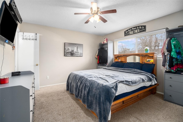 carpeted bedroom featuring a textured ceiling and ceiling fan