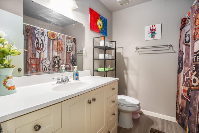 bathroom with vanity, hardwood / wood-style floors, and toilet