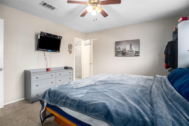 carpeted bedroom with a textured ceiling and ceiling fan