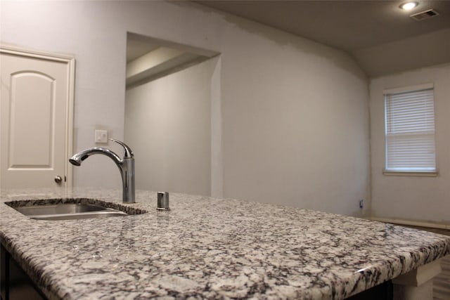 interior space with light stone counters and sink