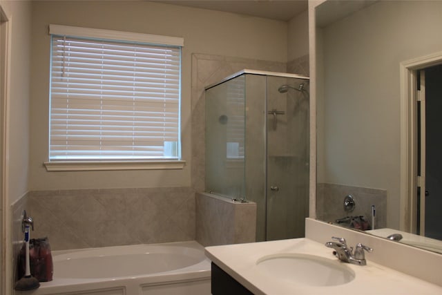 bathroom with vanity and shower with separate bathtub