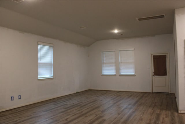 empty room with vaulted ceiling and dark wood-type flooring