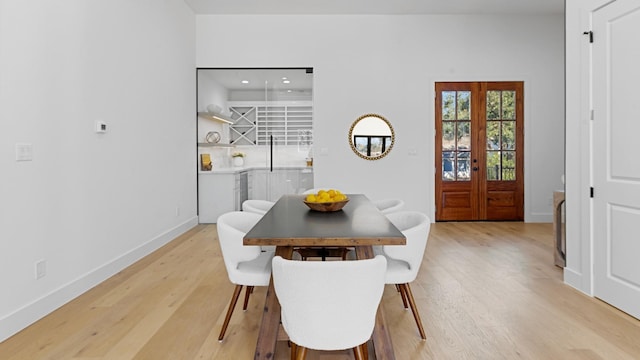 dining space with light hardwood / wood-style floors and french doors