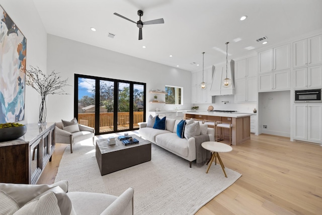 living room featuring light hardwood / wood-style floors and ceiling fan