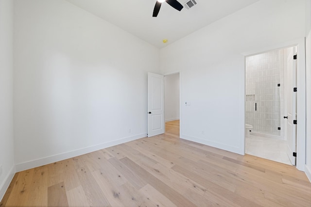 unfurnished bedroom with a ceiling fan, visible vents, baseboards, light wood-type flooring, and ensuite bath