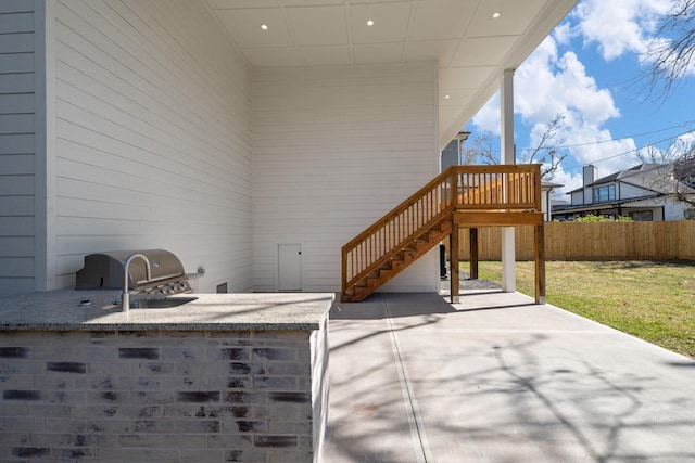 view of patio featuring fence, grilling area, and stairs